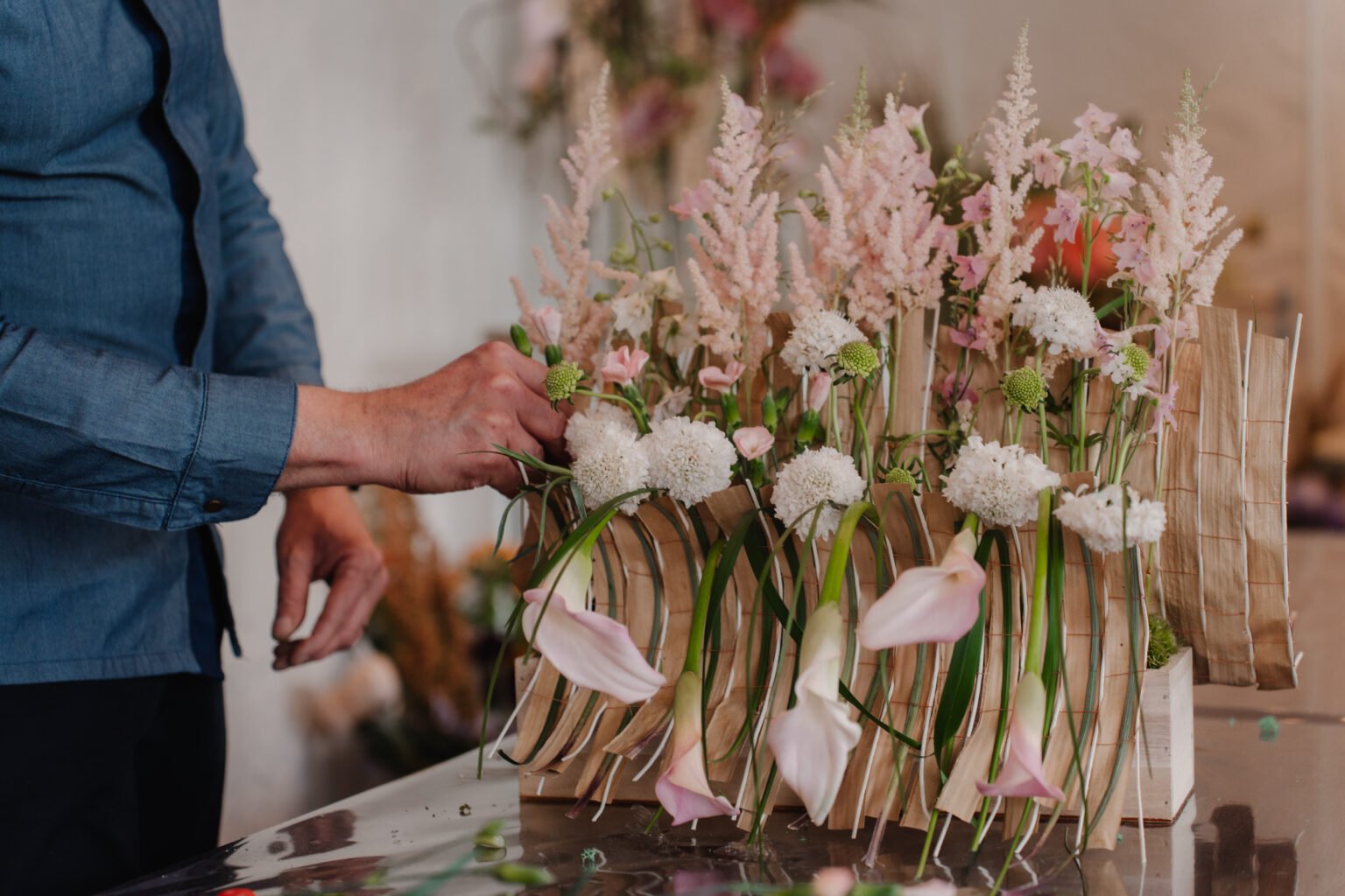 Hands arranging pink flowers during the workshop