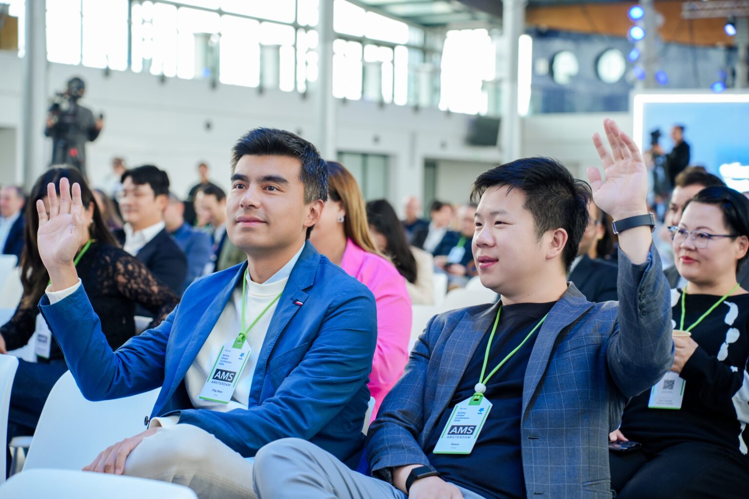 Conference attendees raising their hands during a session